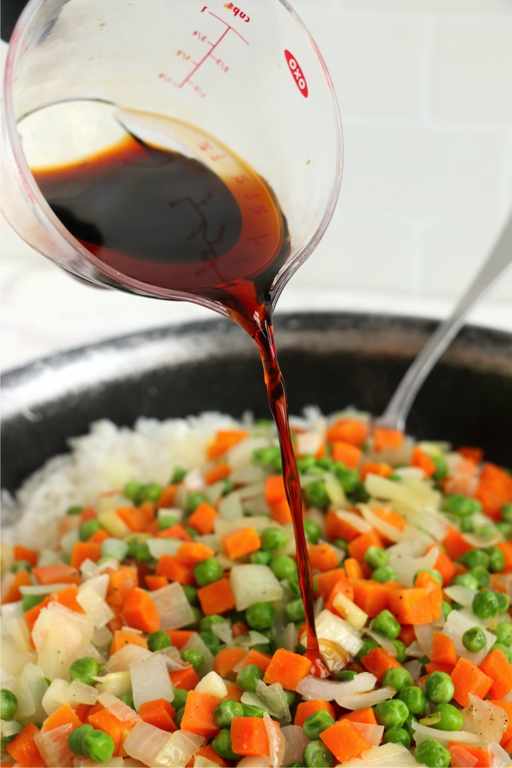 Adding soy sauce to fried rice