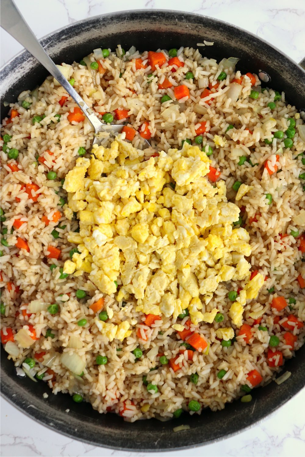 Adding scrambled eggs to fried rice