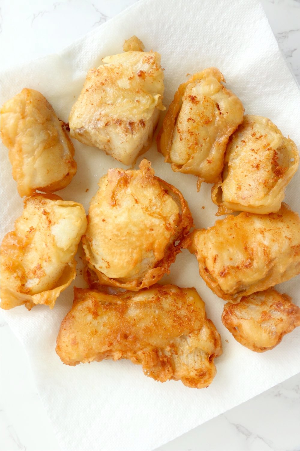 fried fish sitting on paper towel