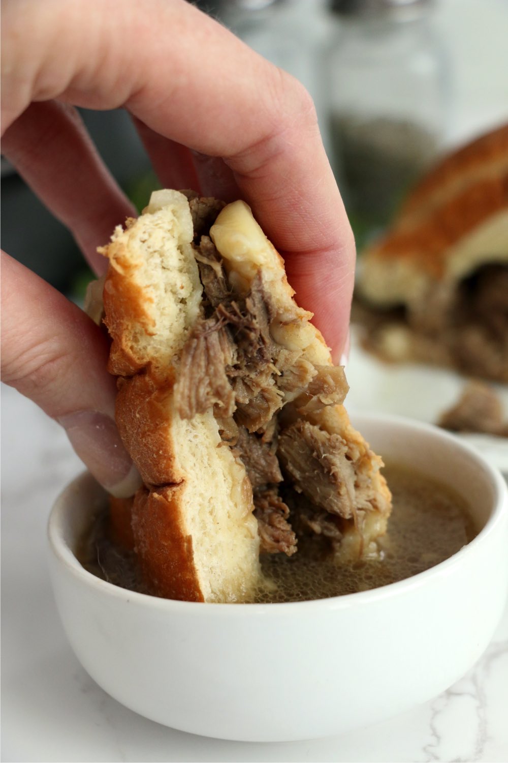 dipping sandwich into au jus