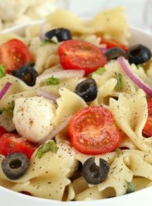 bowl of pasta with tomatoes and black olives