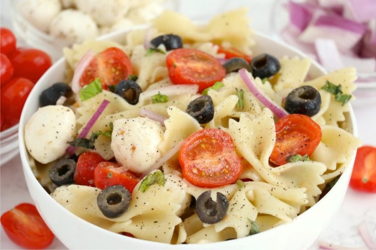 bowl of pasta with tomatoes and black olives