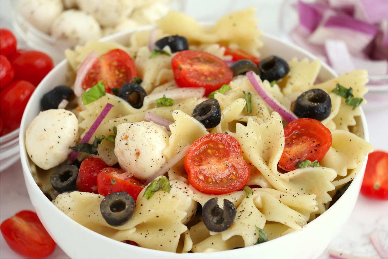 bowl of pasta with tomatoes and black olives