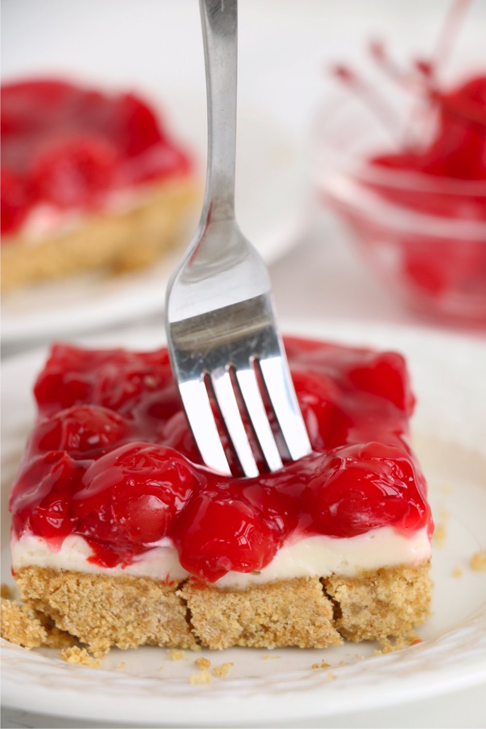 putting a fork into a cherry cheesecake bar