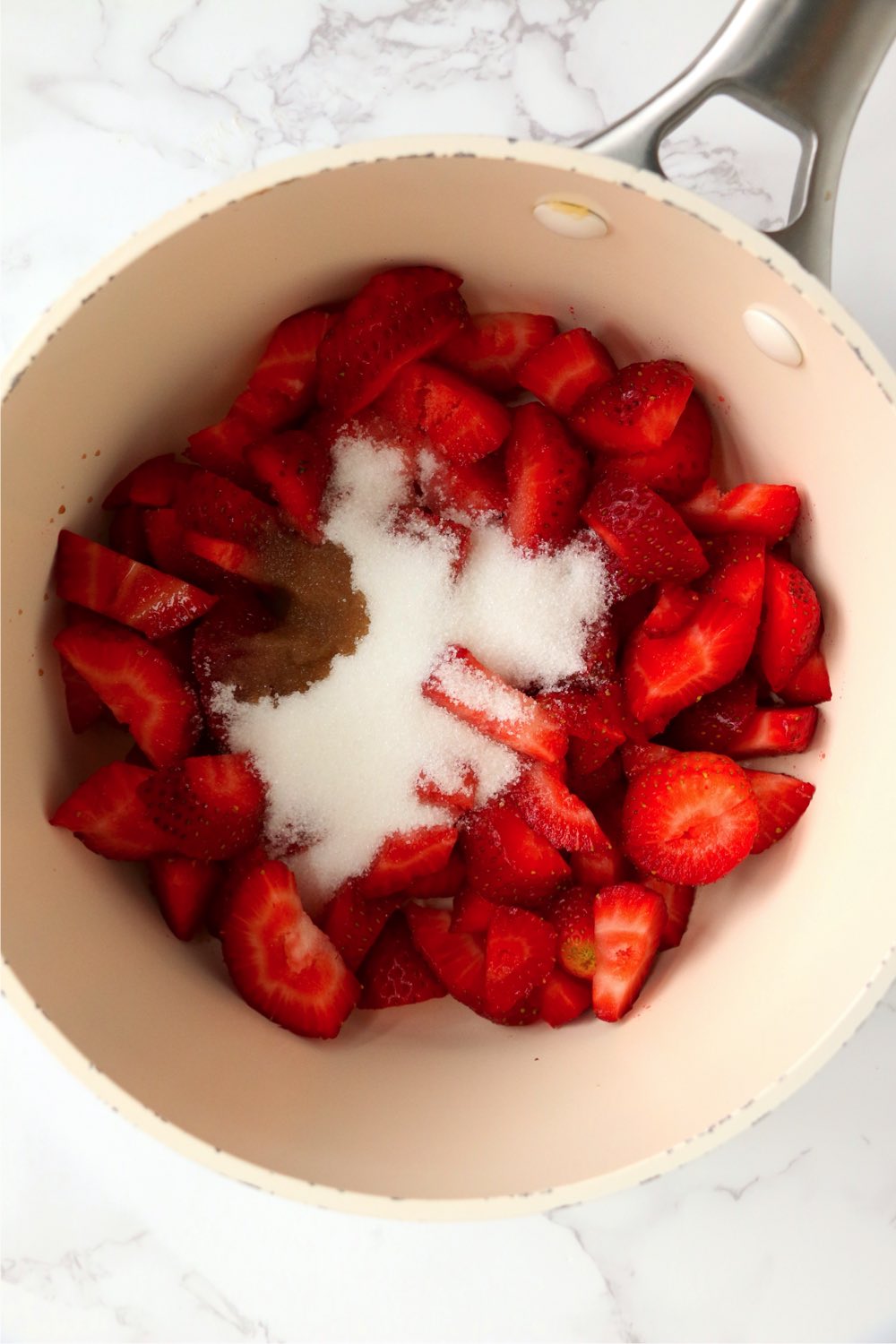 saucepan filled with sliced strawberries and sugar