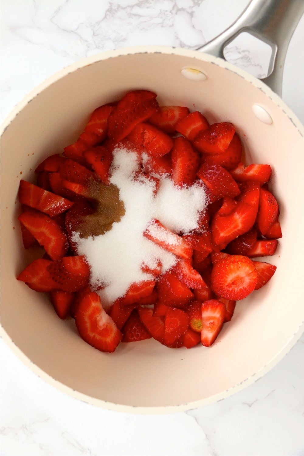 saucepan filled with sliced strawberries and sugar