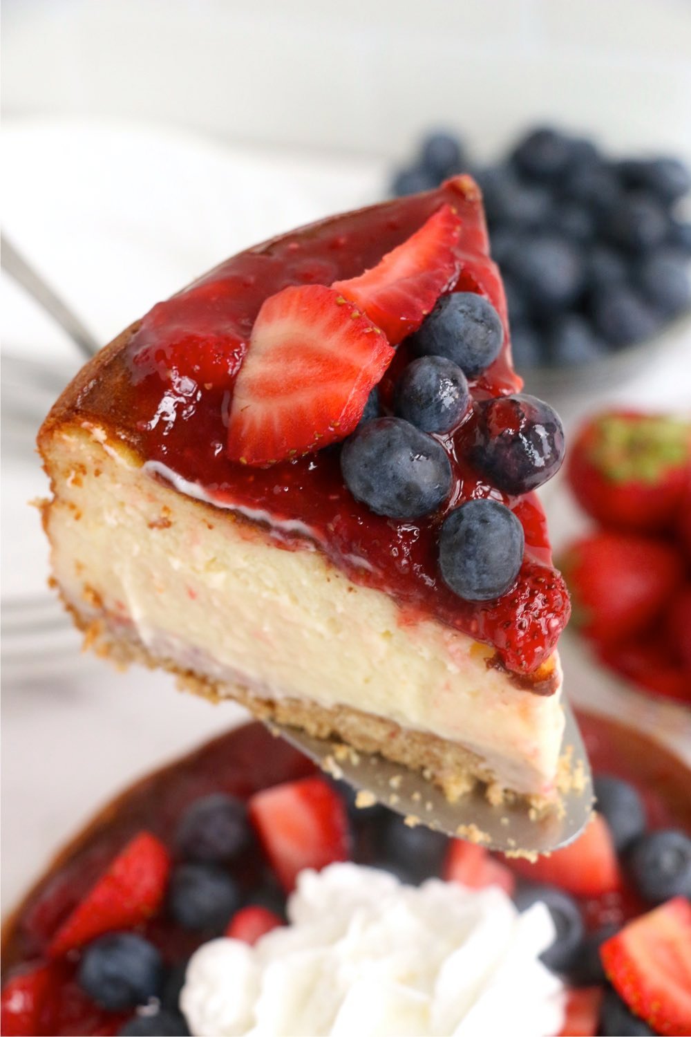 server holding piece of berry cheesecake