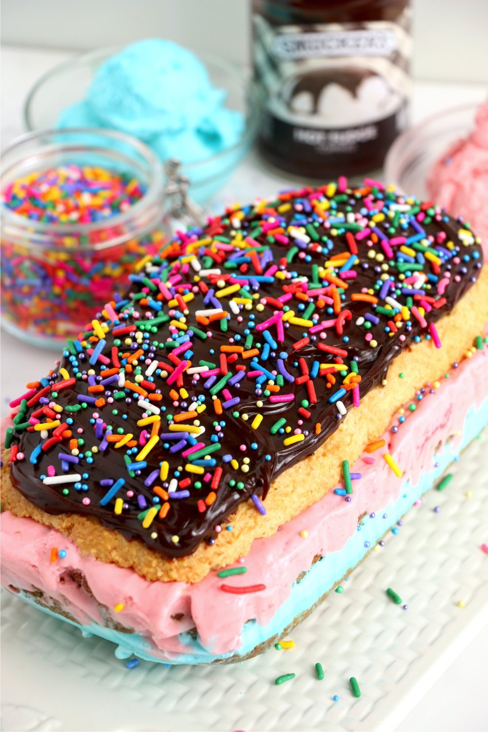 layered cake with ice cream, fudge and sprinkles
