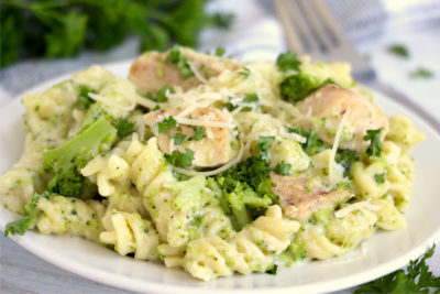 plate of rotini, chicken and broccoli with Parmesan cheese garnish