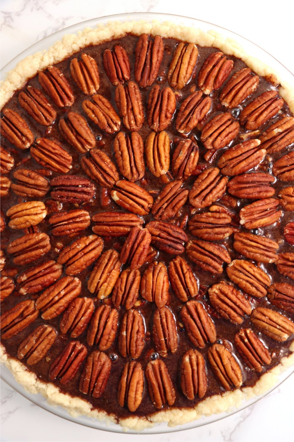Decorative arrangement of pecans on top of a pie