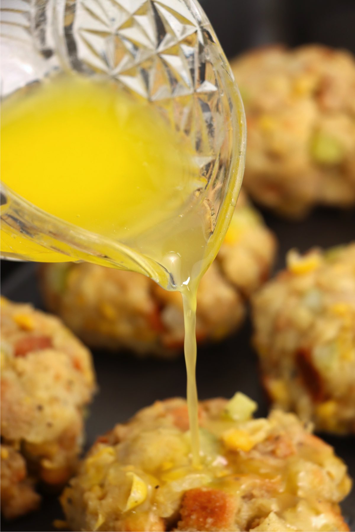 Pouring melted butter over Thanksgiving dressing balls