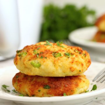 stack of crab cakes on a plate in front of an air fryer