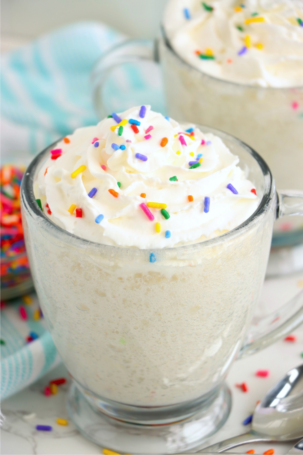 mug cake in a glass with whipped topping and sprinkles
