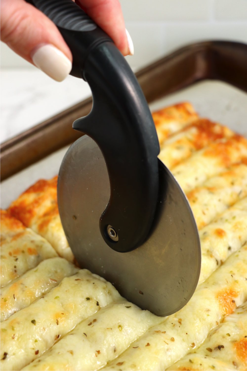 Cutting through breadsticks with a pizza cutter