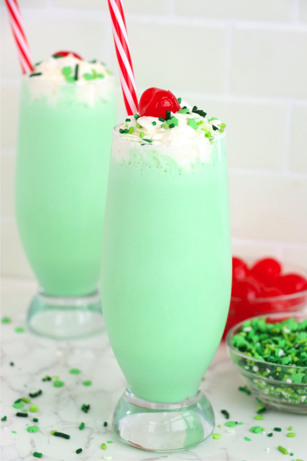 Two homemade Shamrock Shakes topped with cherries