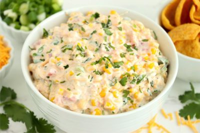 bowl of corn dip surrounded by chips and fresh ingredients