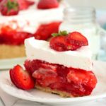 piece of frosted strawberry pie with fresh berries on top
