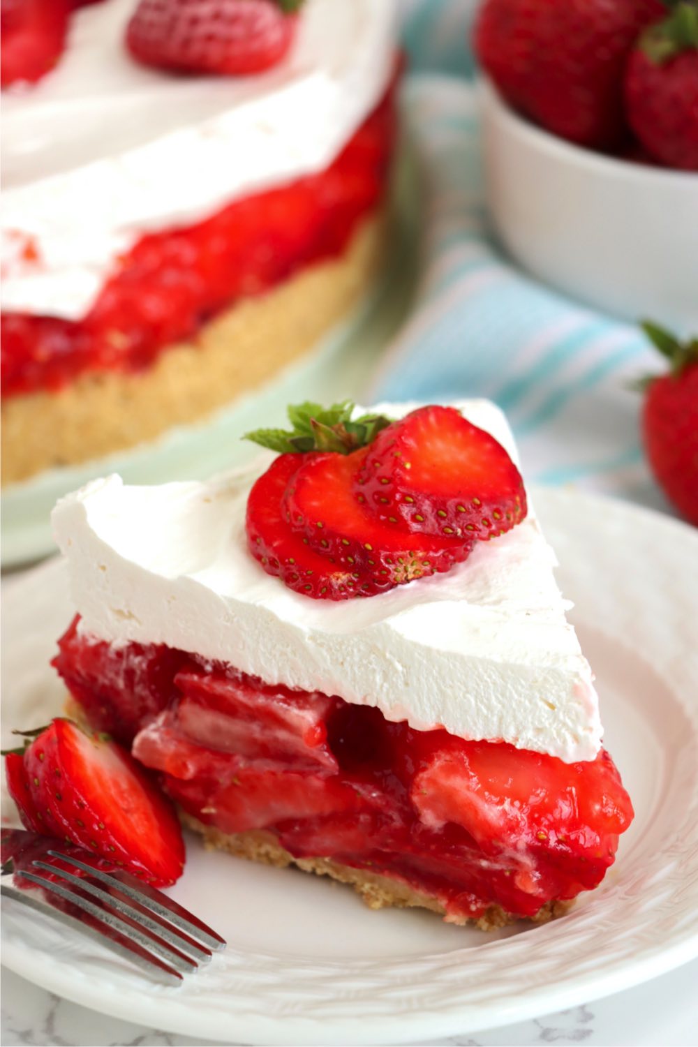 piece of strawberry pie with fresh strawberry garnish