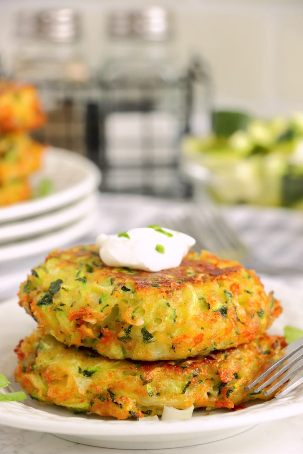 fried zucchini patties with sour cream dollop