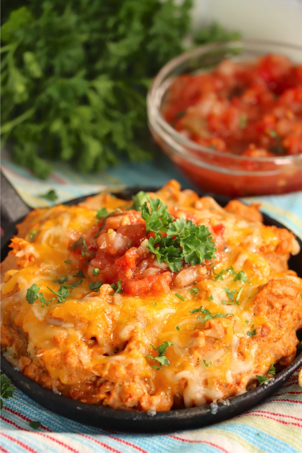 bean dip topped with tomatoes and parsley
