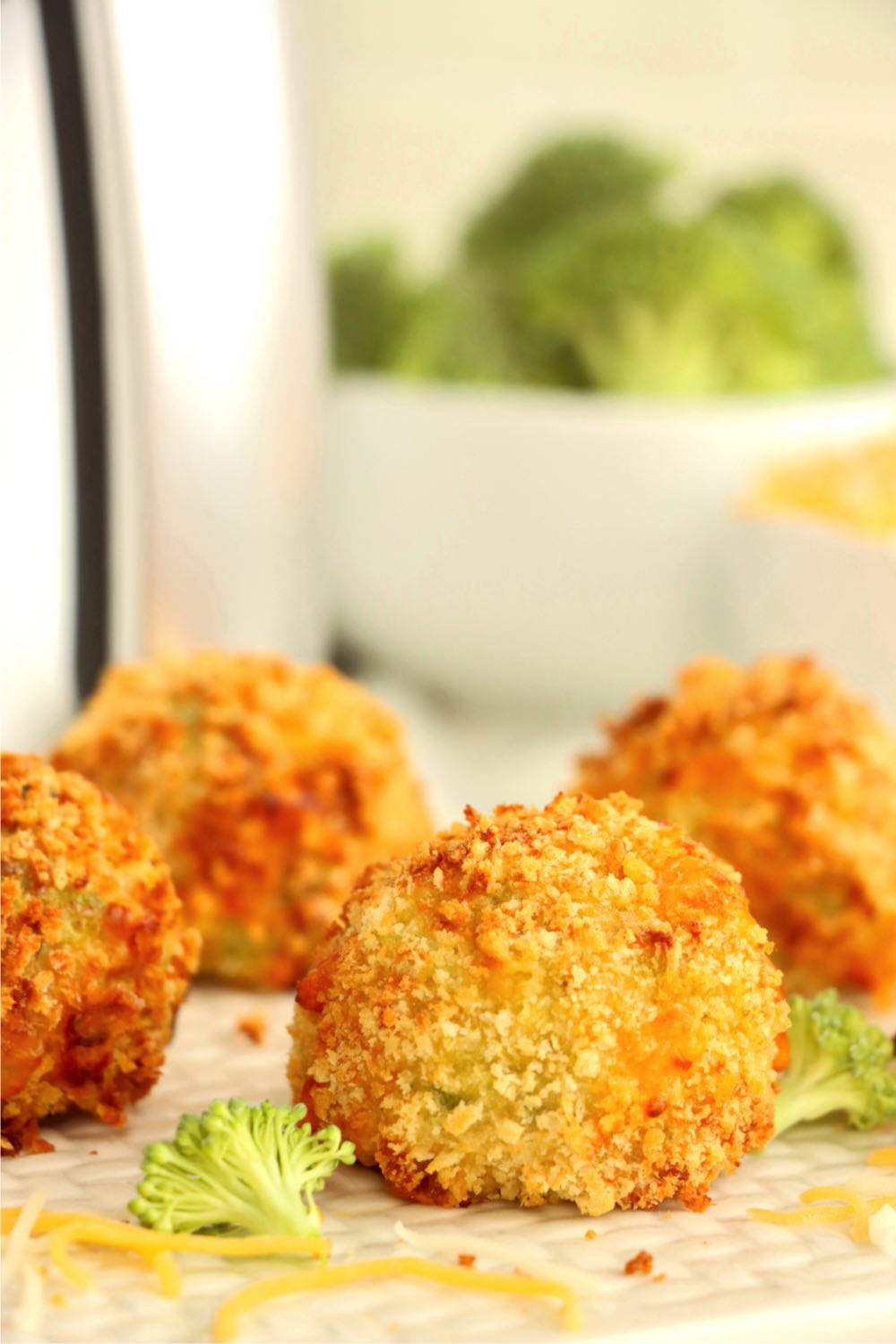 plate of golden cheese balls in front of air fryer