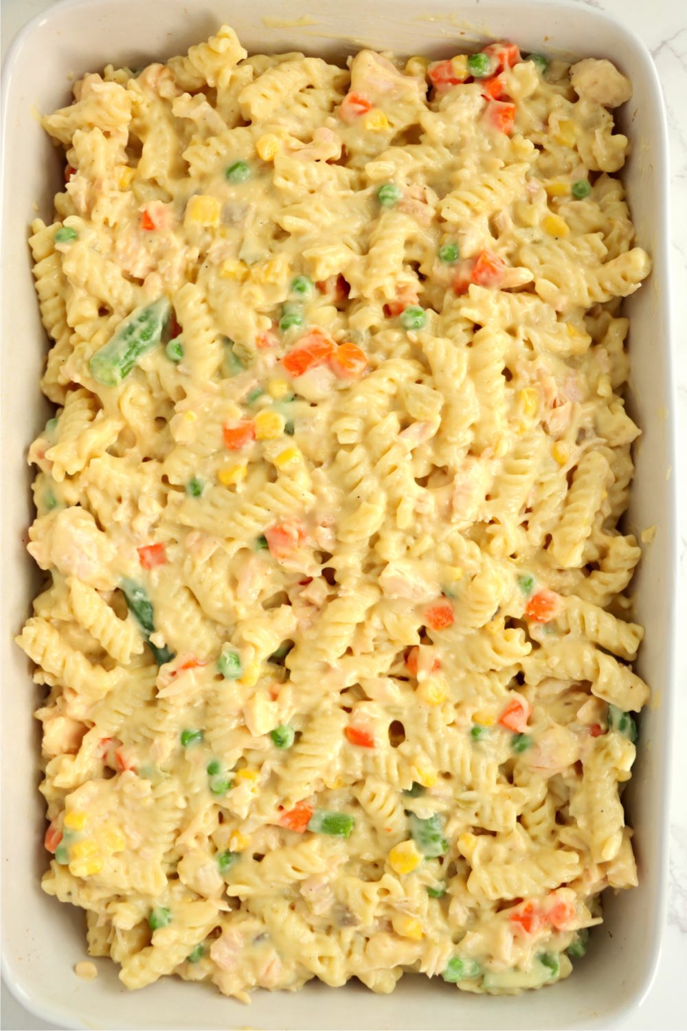 Noodles and vegetables spread out in a baking pan