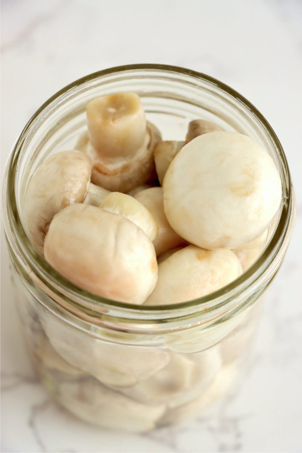 Glass mason jar filled with clean fresh button mushrooms