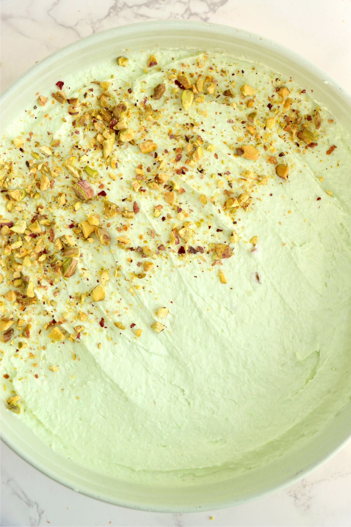 Green cheesecake with a sprinkling of crushed pistachio nuts