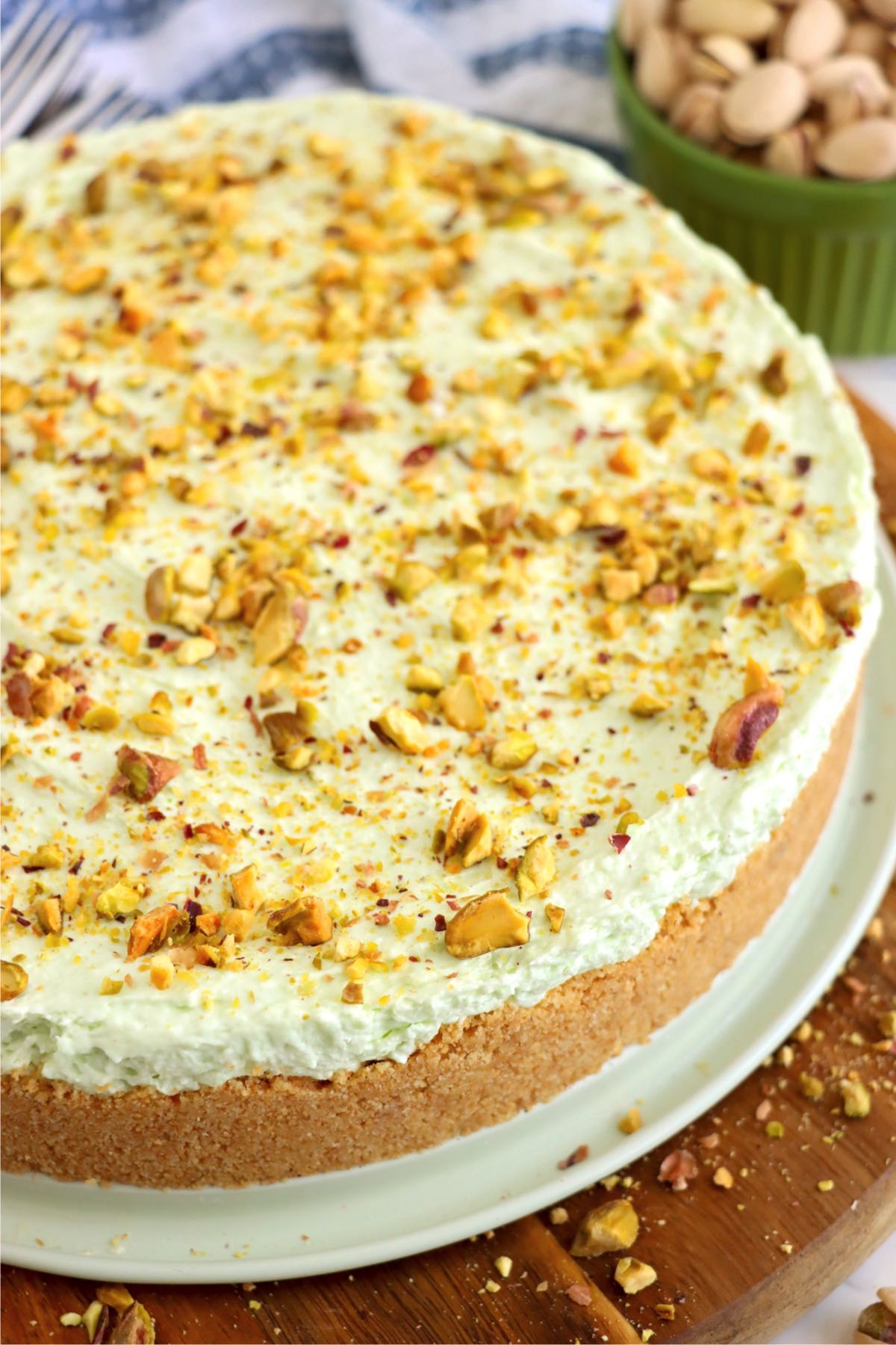 Whole pistachio cheesecake covered with crushed pistachios