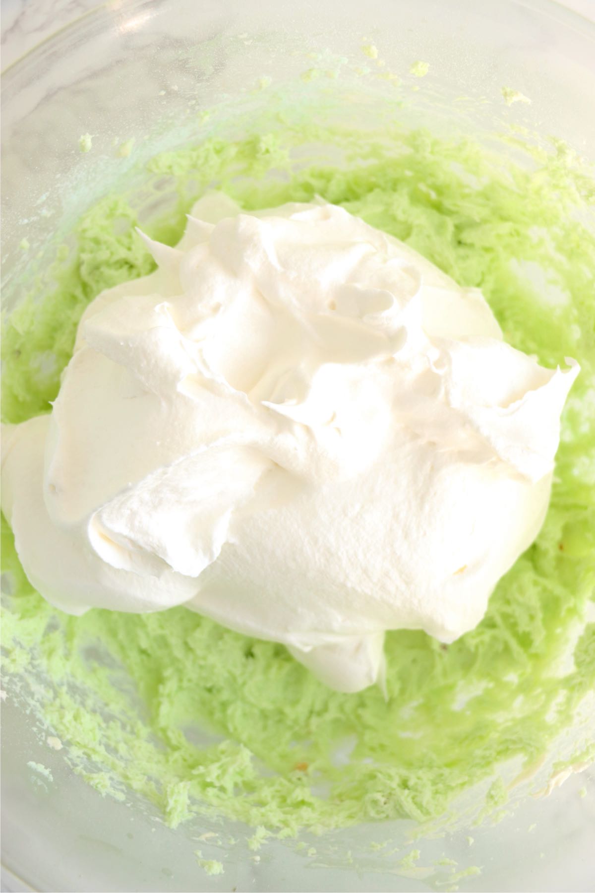 Dollop of whipped topping on top of pistachio pudding