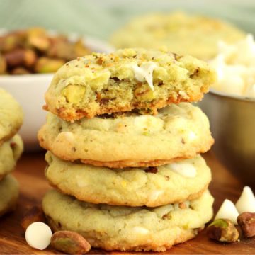 stack of pistachio cookies with half eaten cookie on top