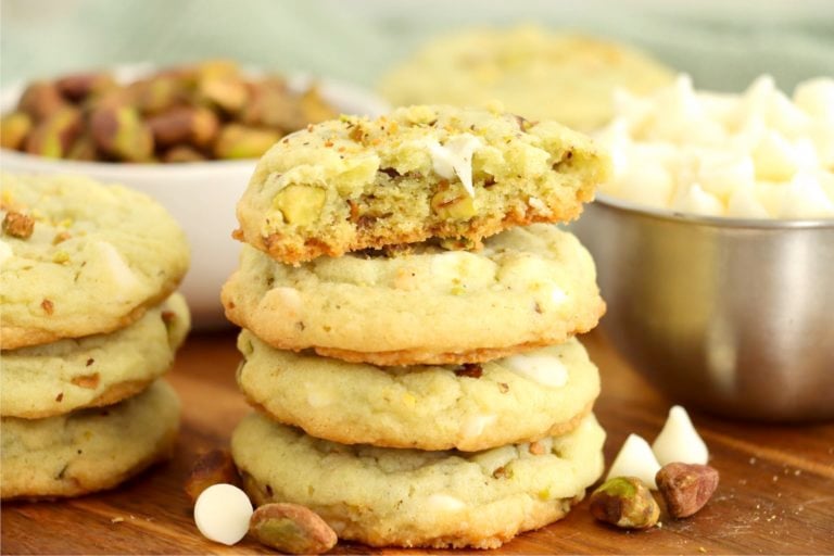 stack of pistachio cookies with half eaten cookie on top