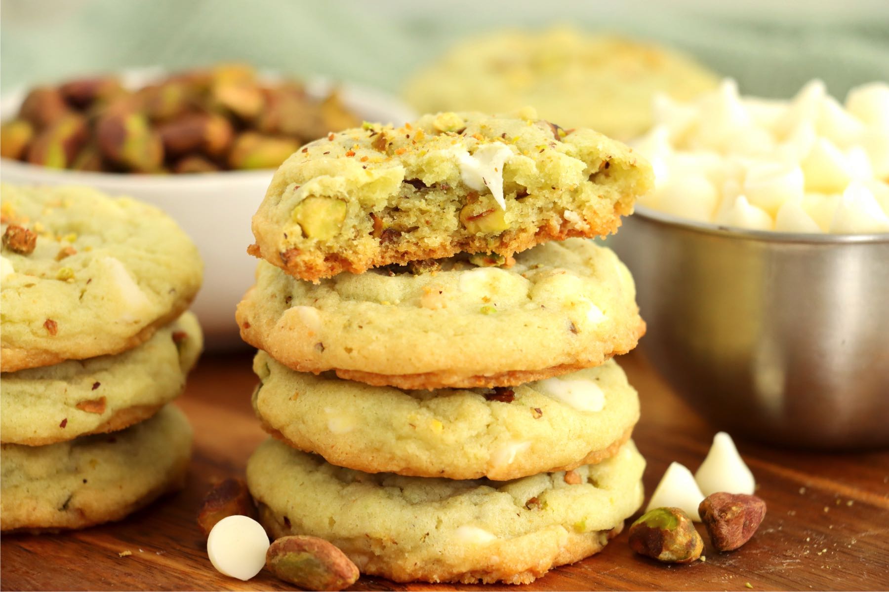 stack of pistachio cookies with half eaten cookie on top
