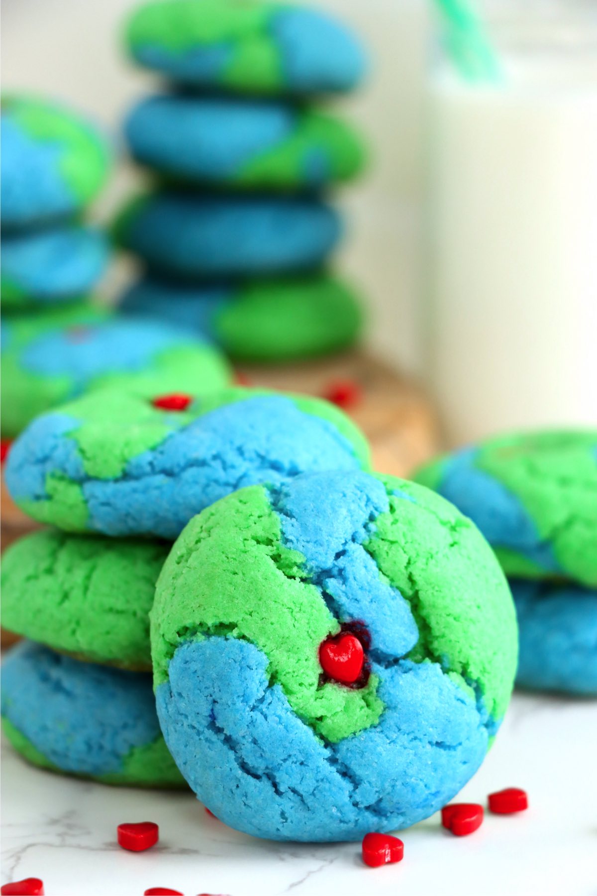 Earth-themed cookie leaning up against a stack of other cookies