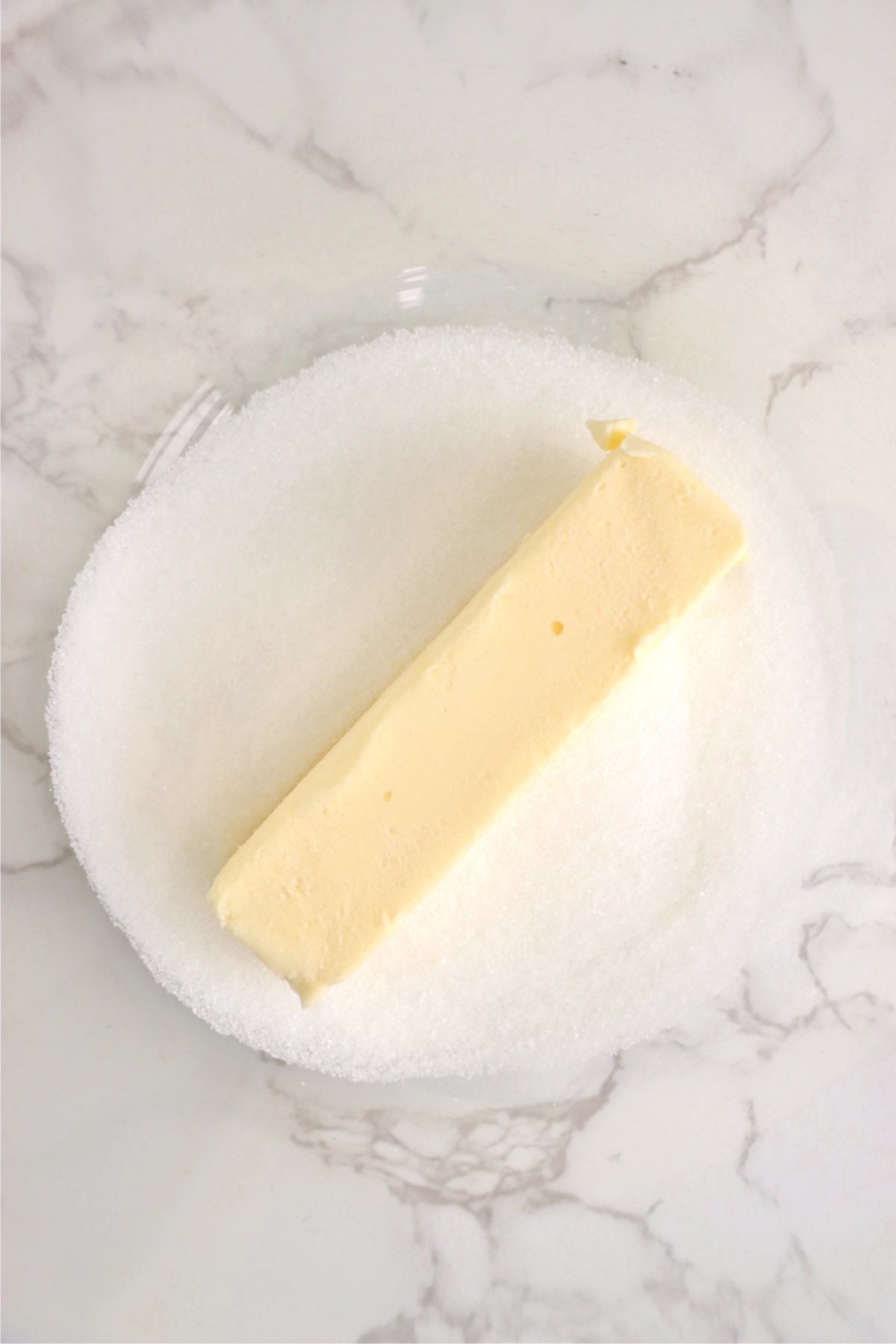 Stick of butter and sugar in a mixing bowl
