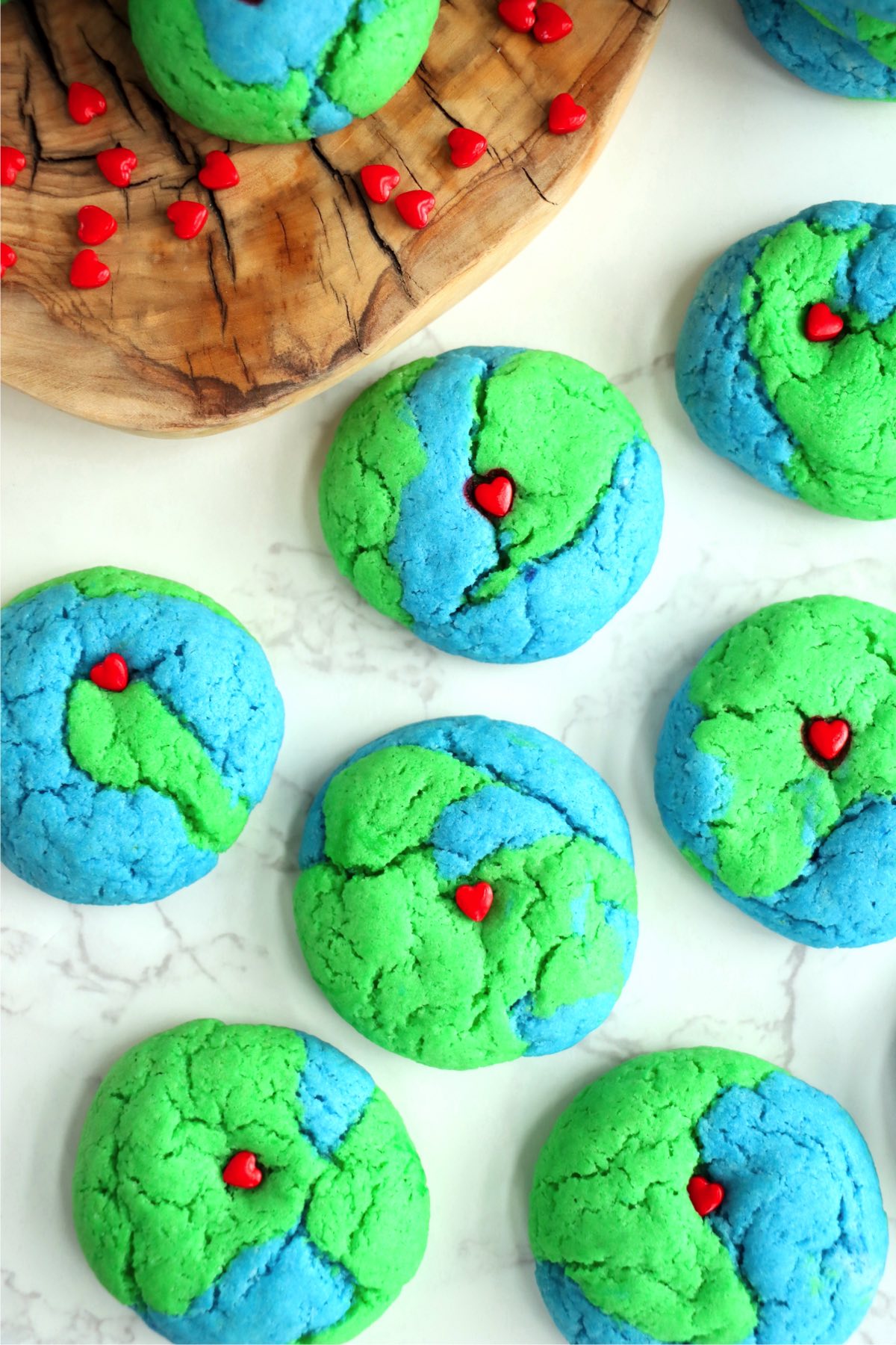 Earth Day cookies cooling on a white marble countertop
