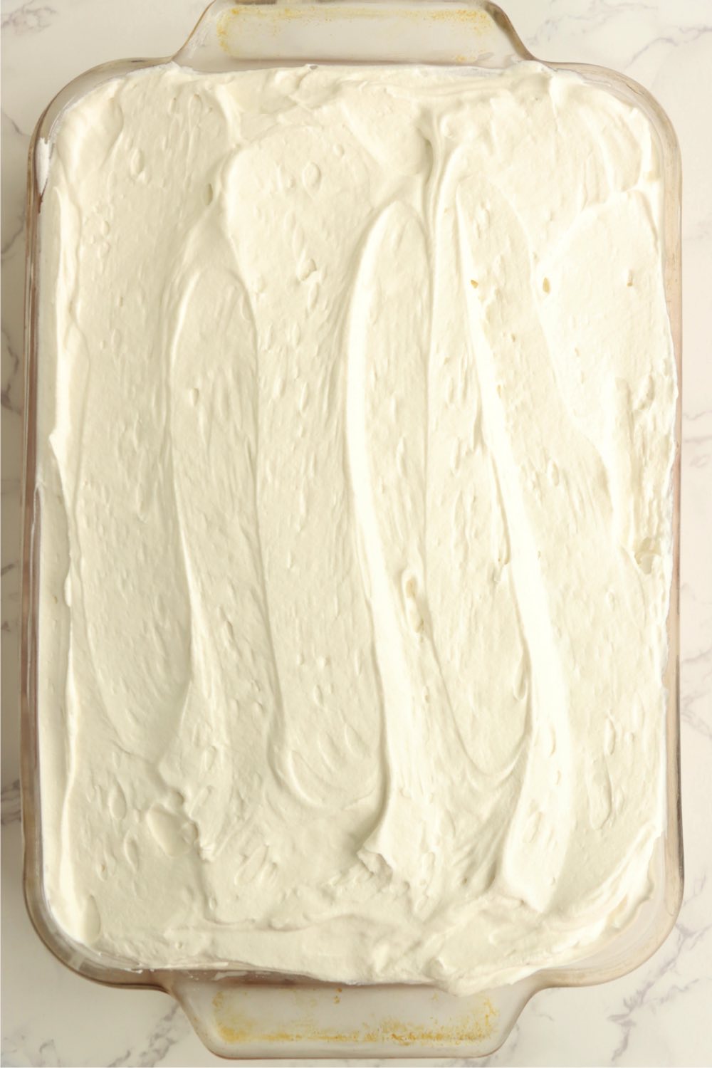 A tres leches cake covered with whipped topping