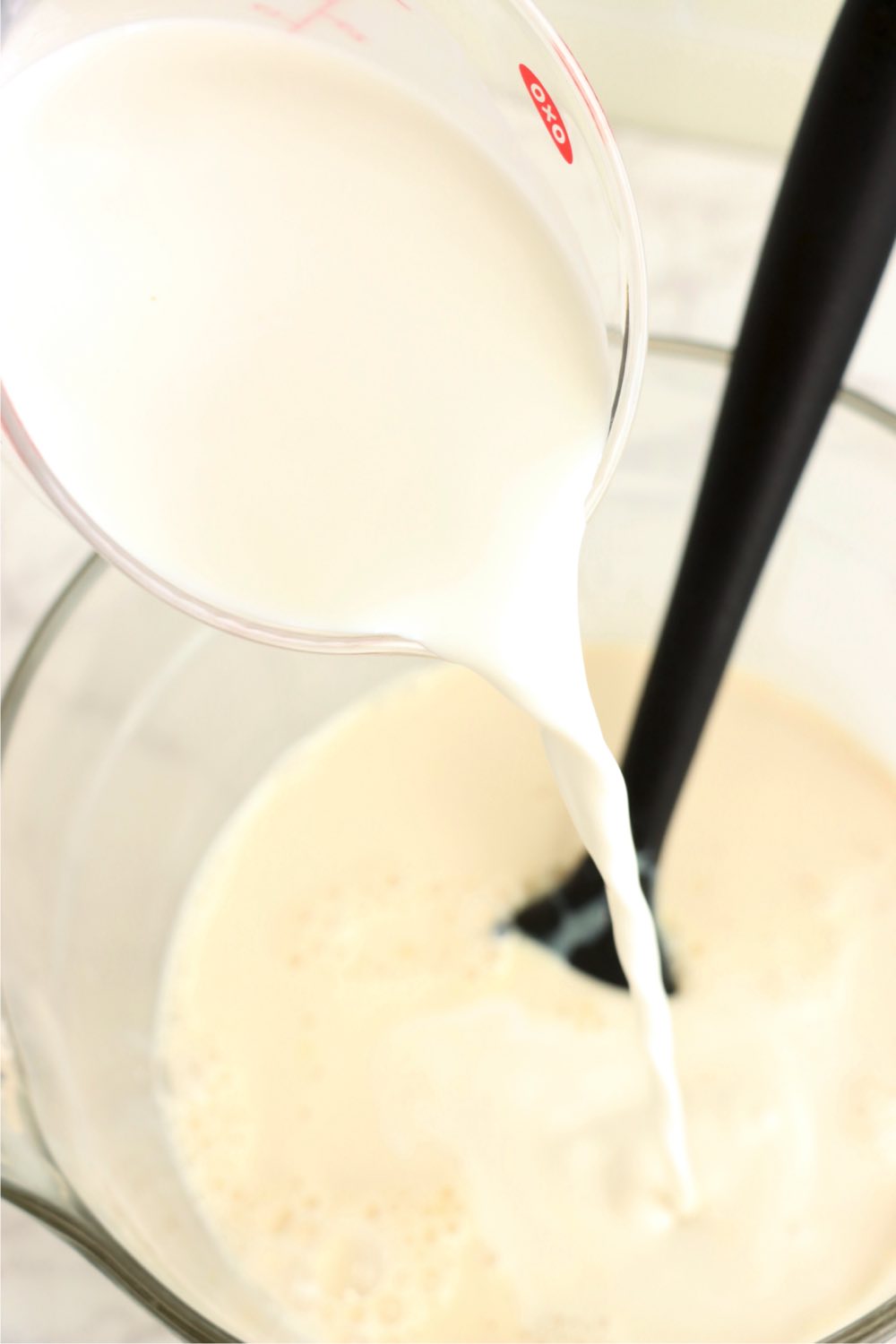 Pouring milk into a tres leches mixture