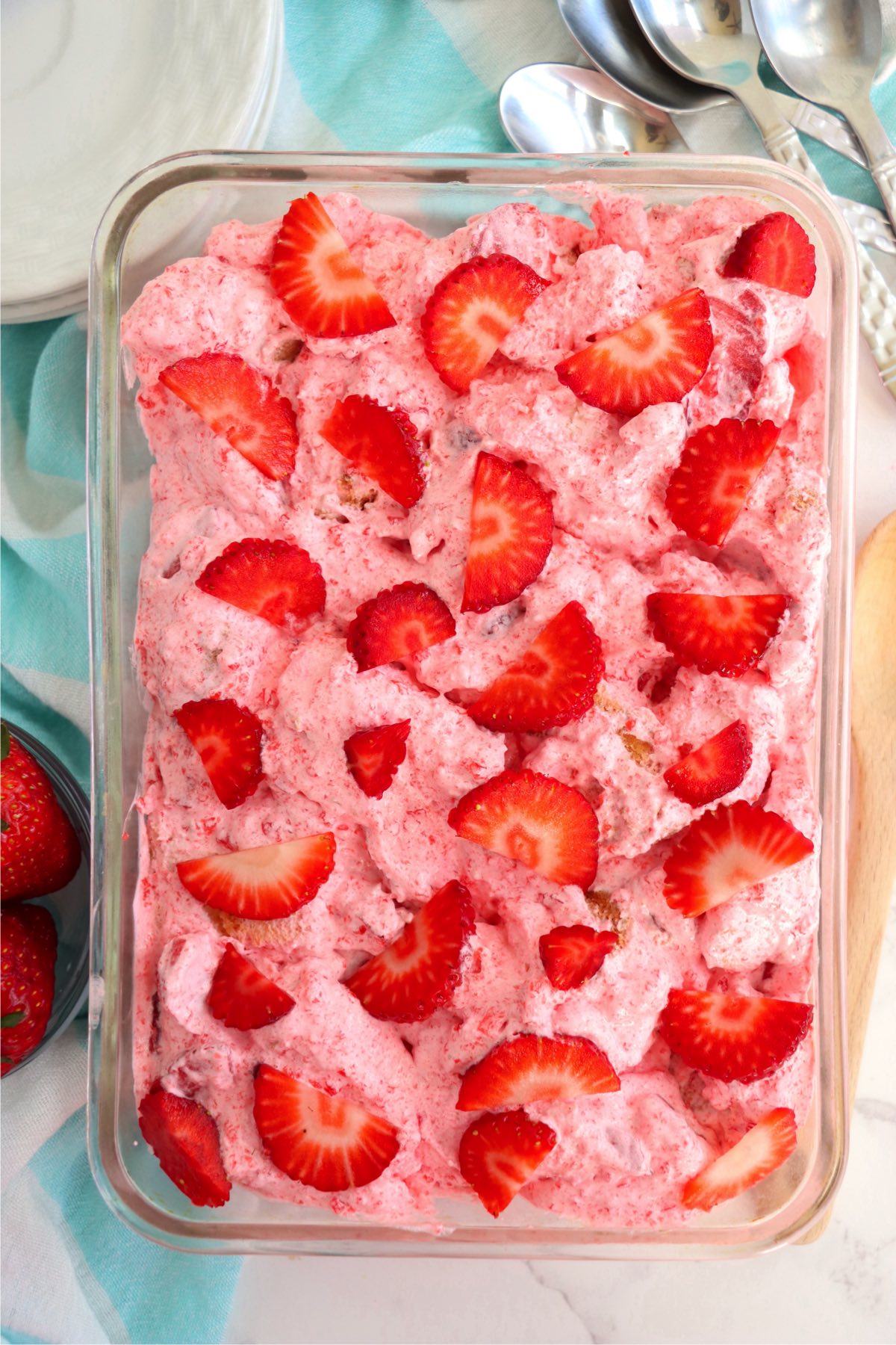 Strawberry jello and angel food cake dessert in a glass cake pan