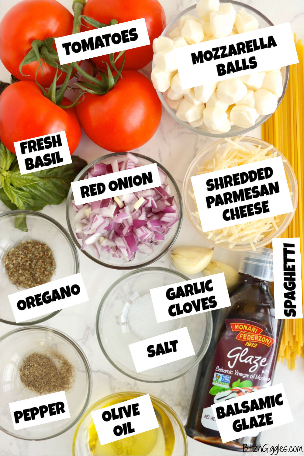 Ingredients for a bruschetta pasta salad on a white marble table