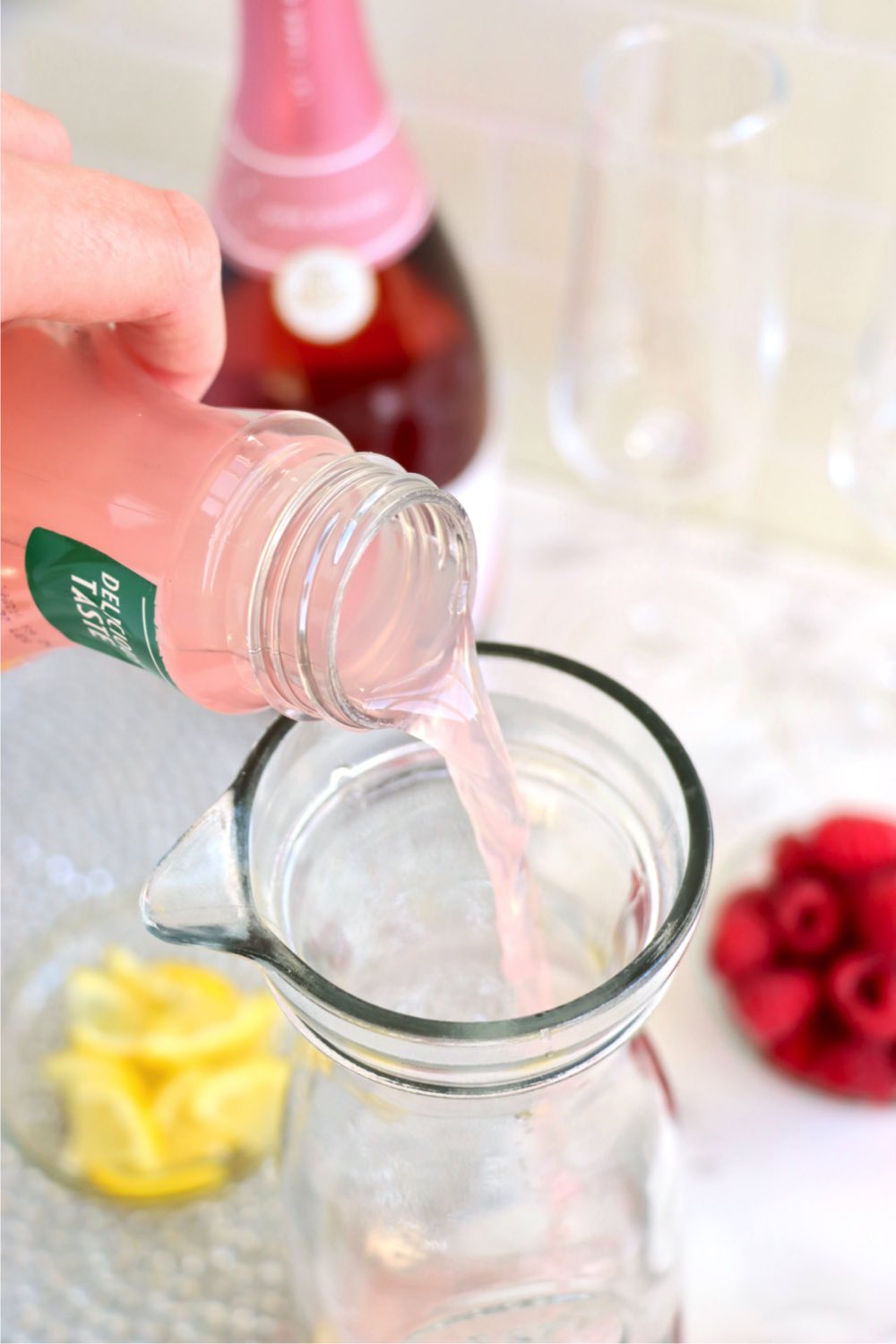 pouring raspberry lemonade into a carafe