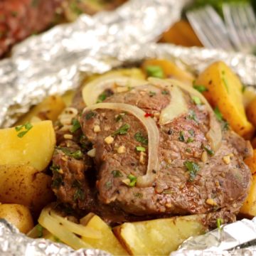 Steak, potatoes and onions in a foil packet.