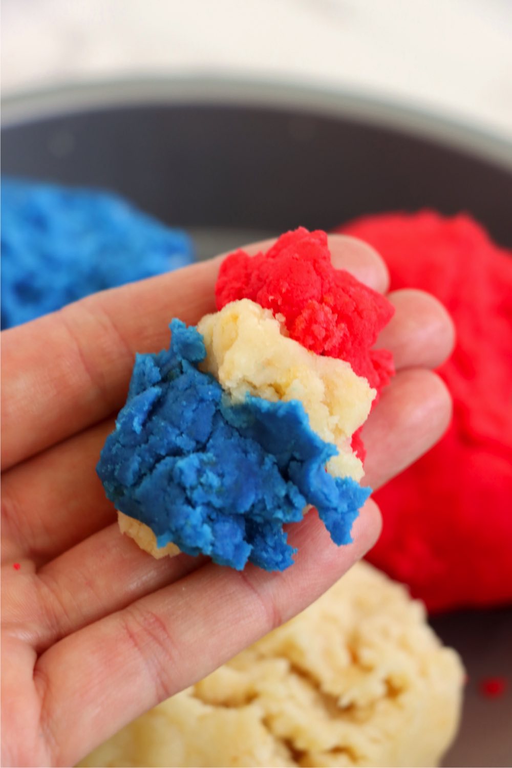 Hand holding red, white and blue cake batter.