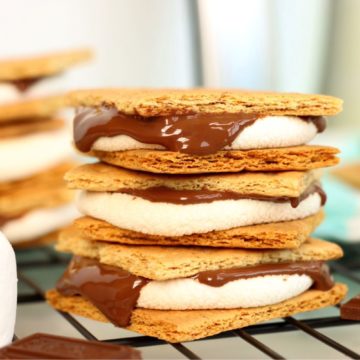 Stack of three s'mores with melted chocolate dripping over the sides.