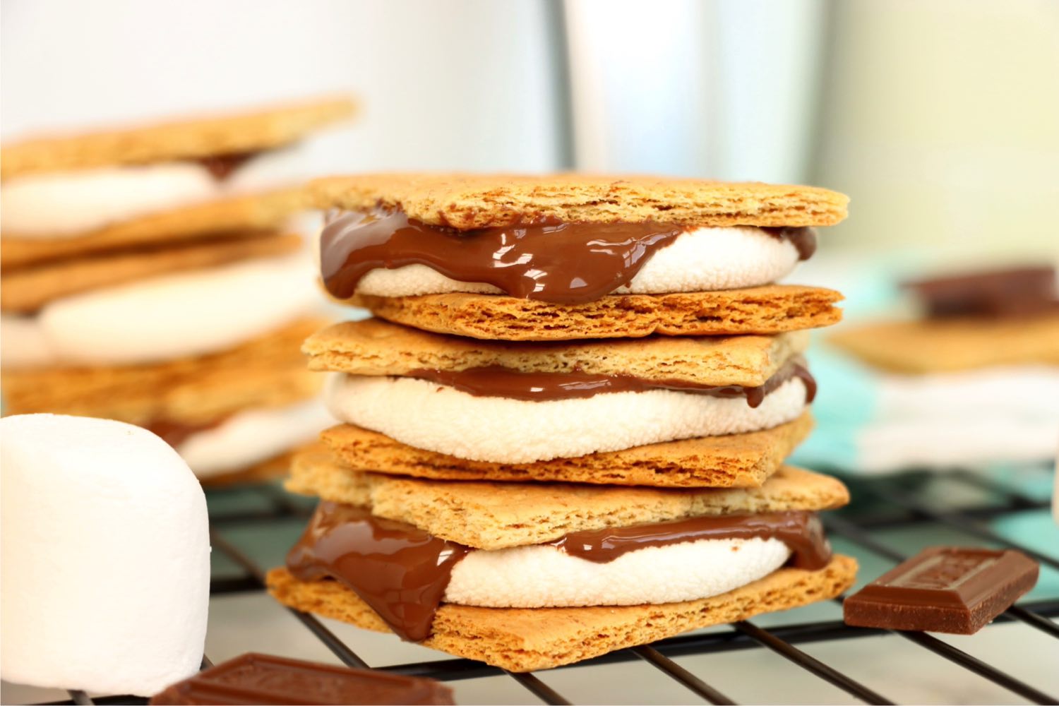 Stack of three s'mores with melted chocolate dripping over the sides.