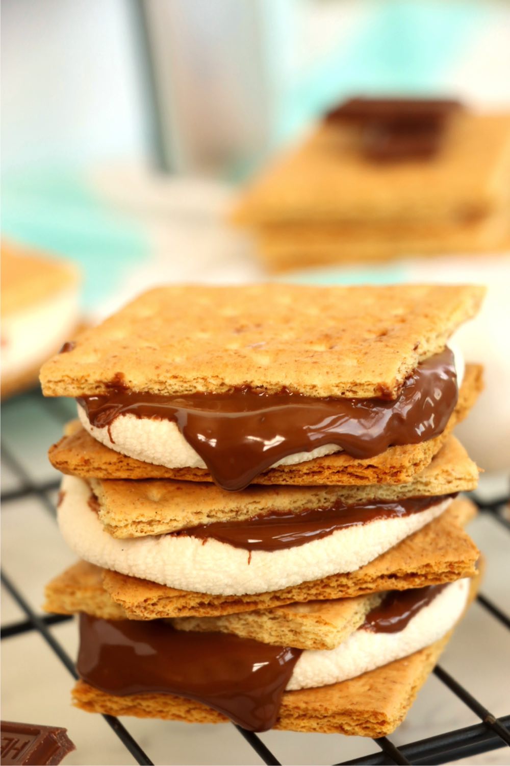 Stack of melty chocolate s'mores on a cooling rack.