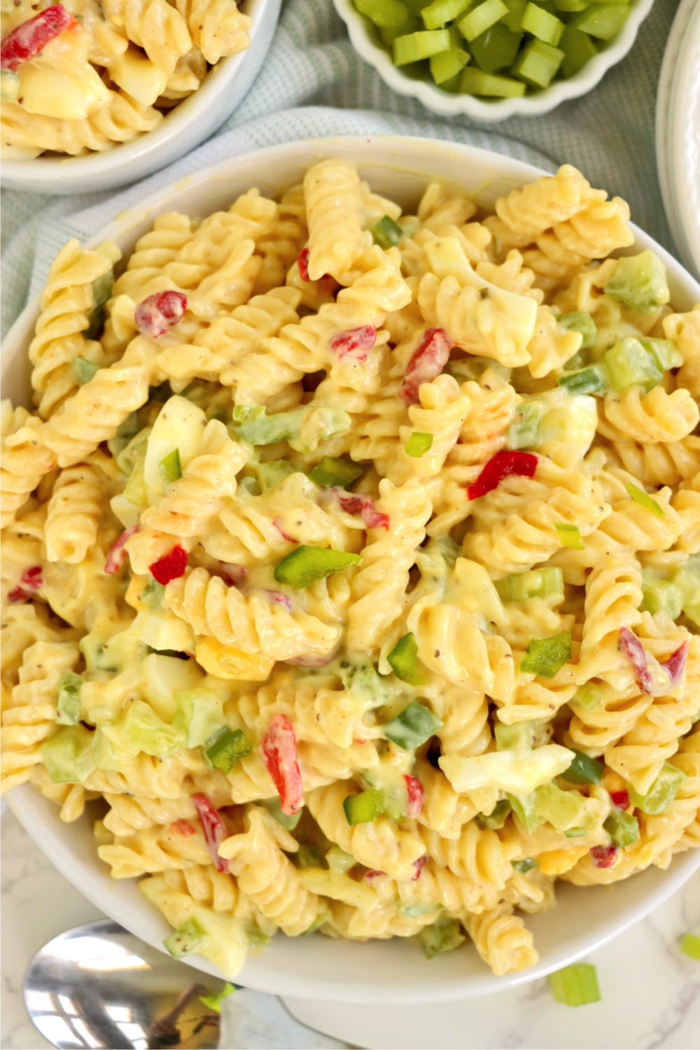 Bowl filled with corkscrew pasta and chopped veggies covered in a creamy dressing.