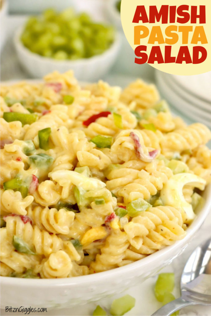 White bowl heaping with rotini pasta and chopped veggies covered in a creamy dressing.