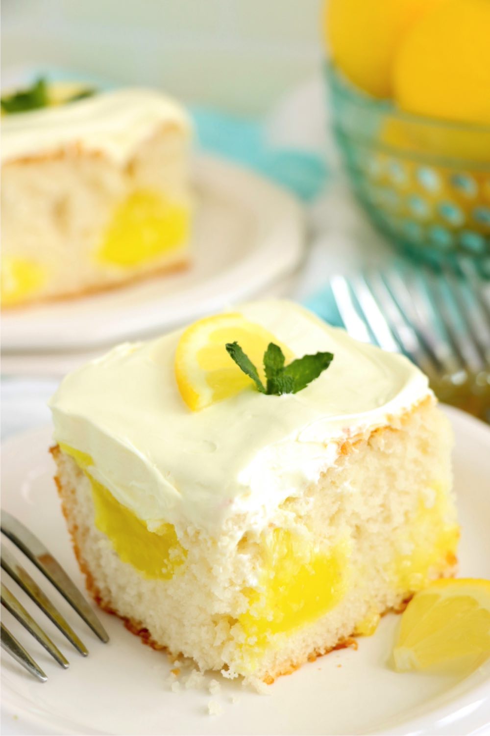 A piece of white cake on a plate with pockets of lemon filling.