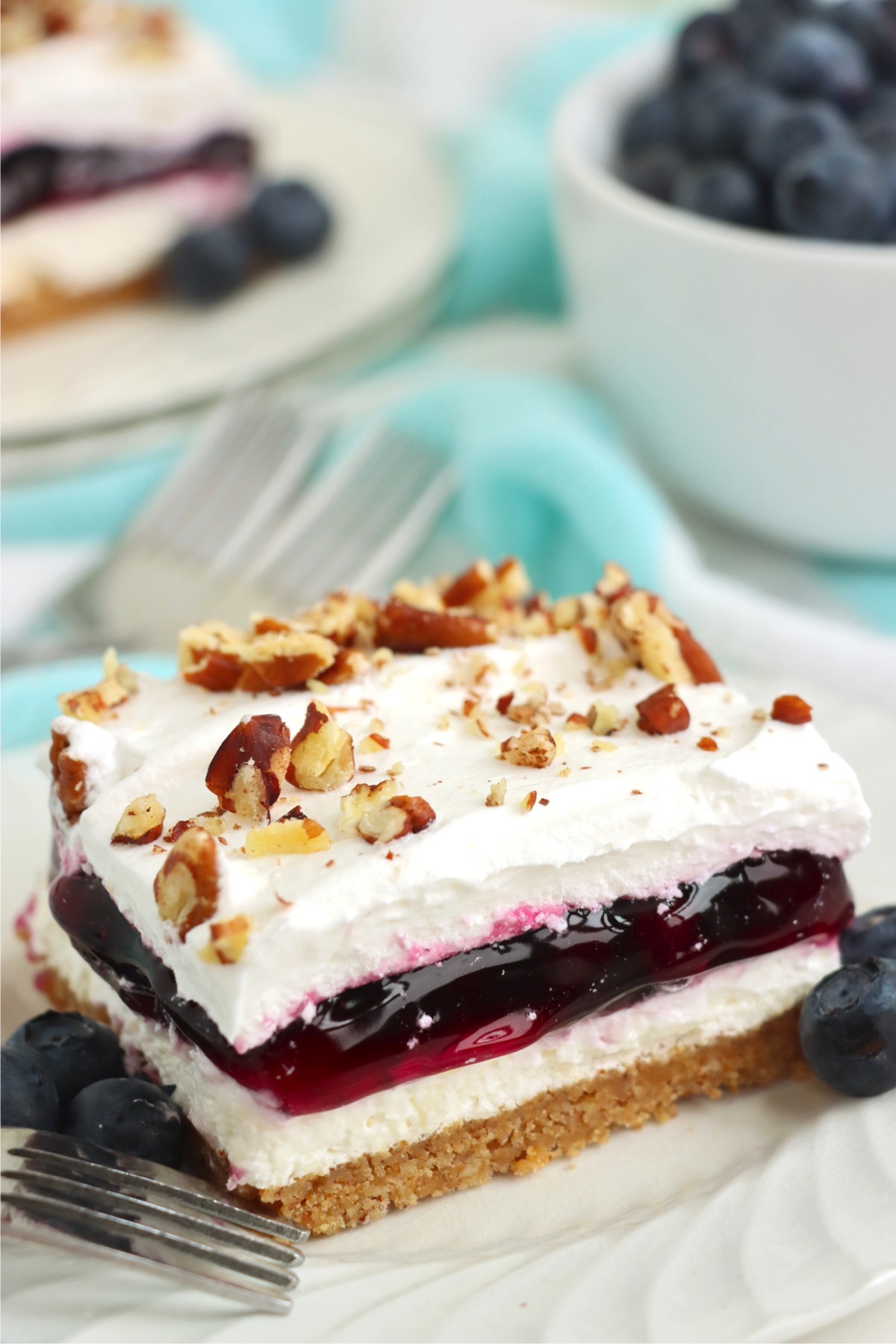 Piece of blueberry layered dessert with pecan topping.